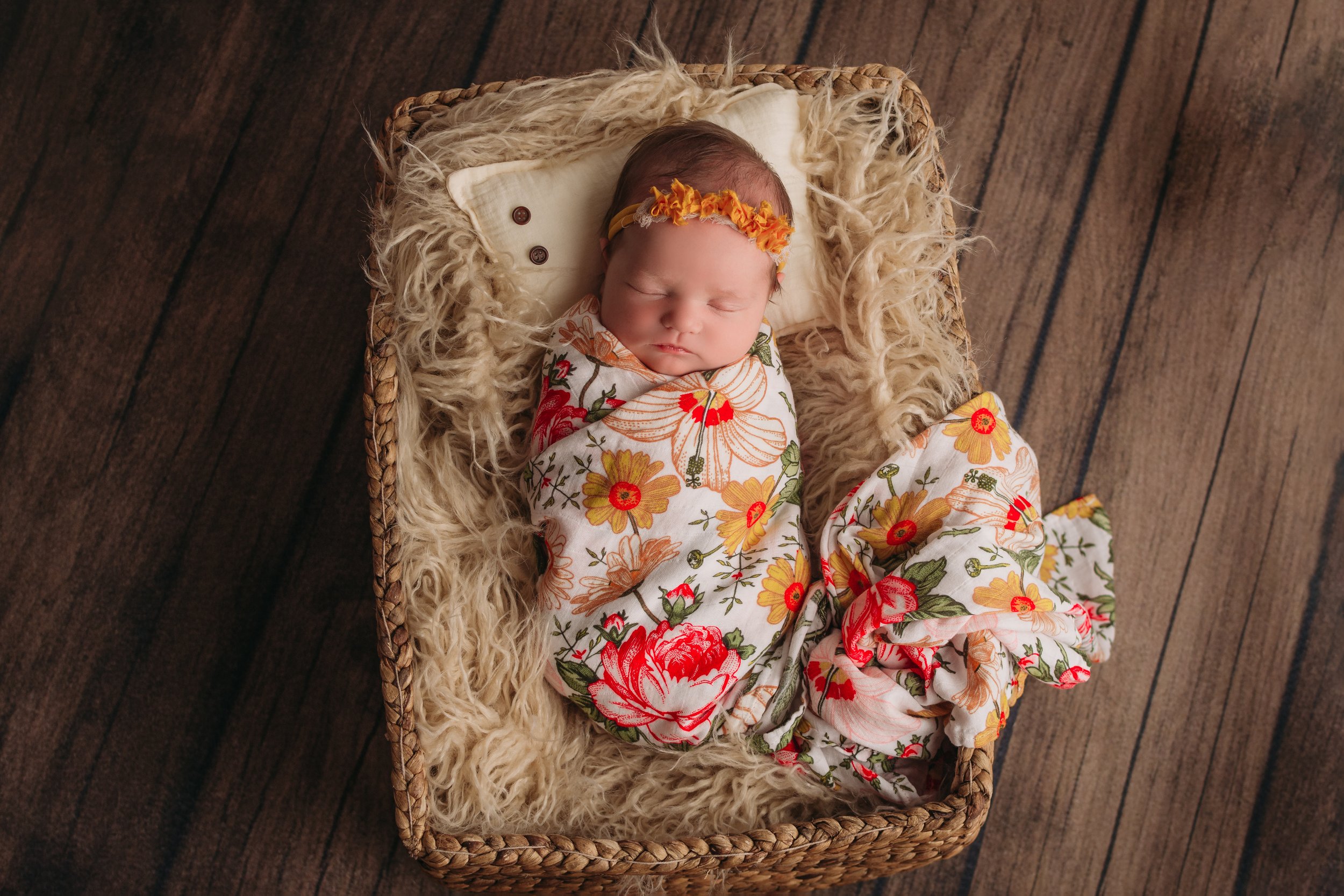newborn baby girl in floral in basket