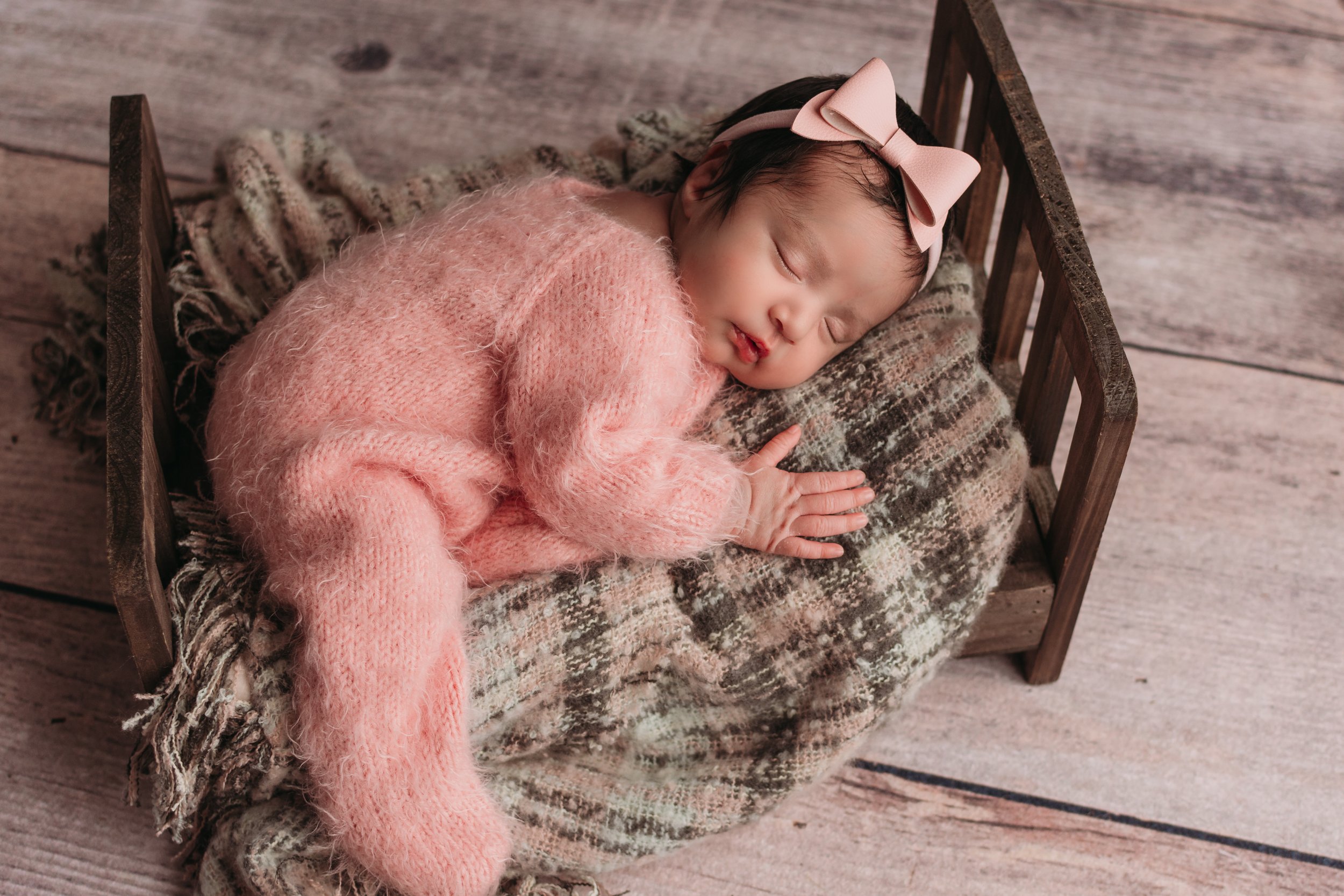 newborn sleeping on baby bed pink