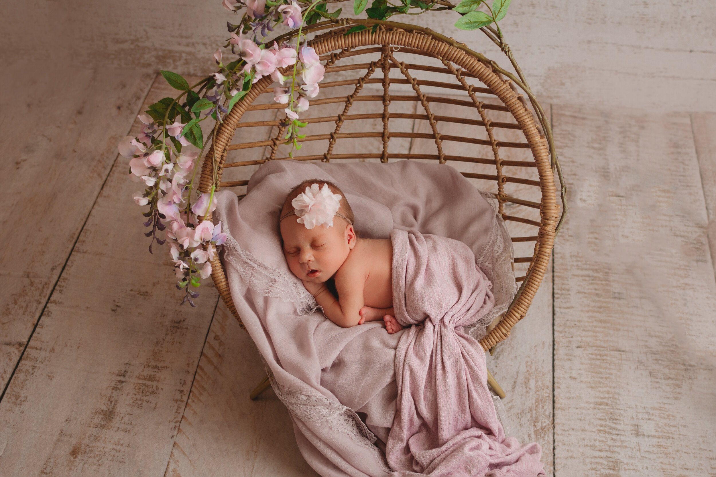 newborn baby girl in purple and flowers