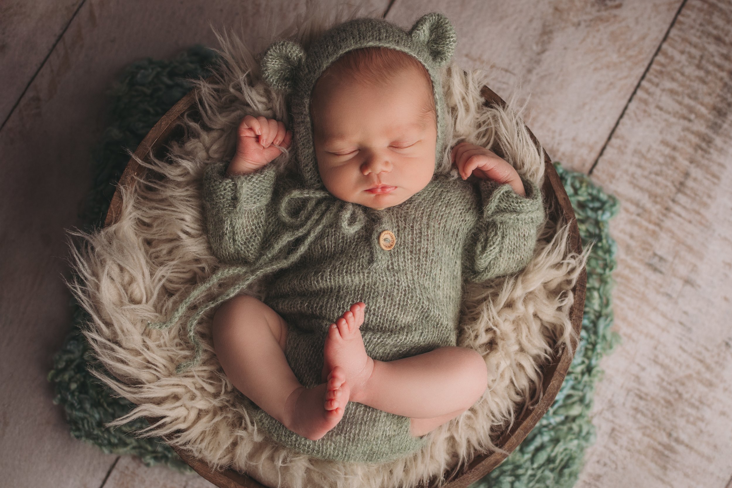 Baby in green with teddy bear ears