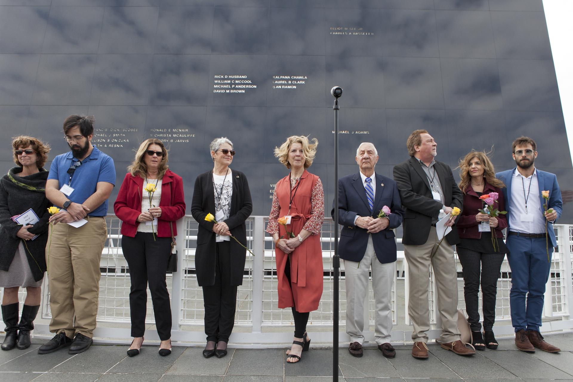The family members of the fallen astronauts stand in front of the Space Mirror Memorial.