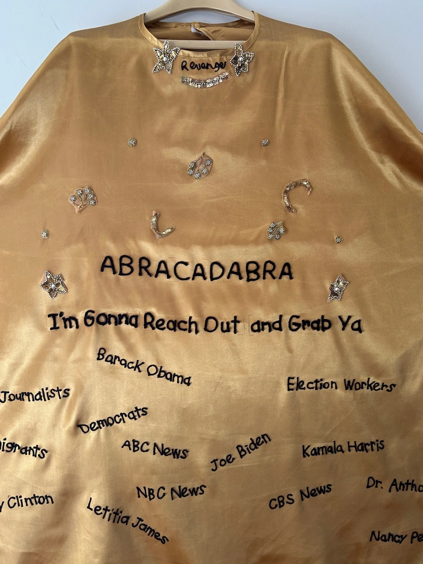   Abracadabra, I’m Gonna Reach Out and Grab Ya, Trump’s Cape of Retribution, 2025, Marsha Borden    “38 x “48, satin, yarn, embroidery floss    