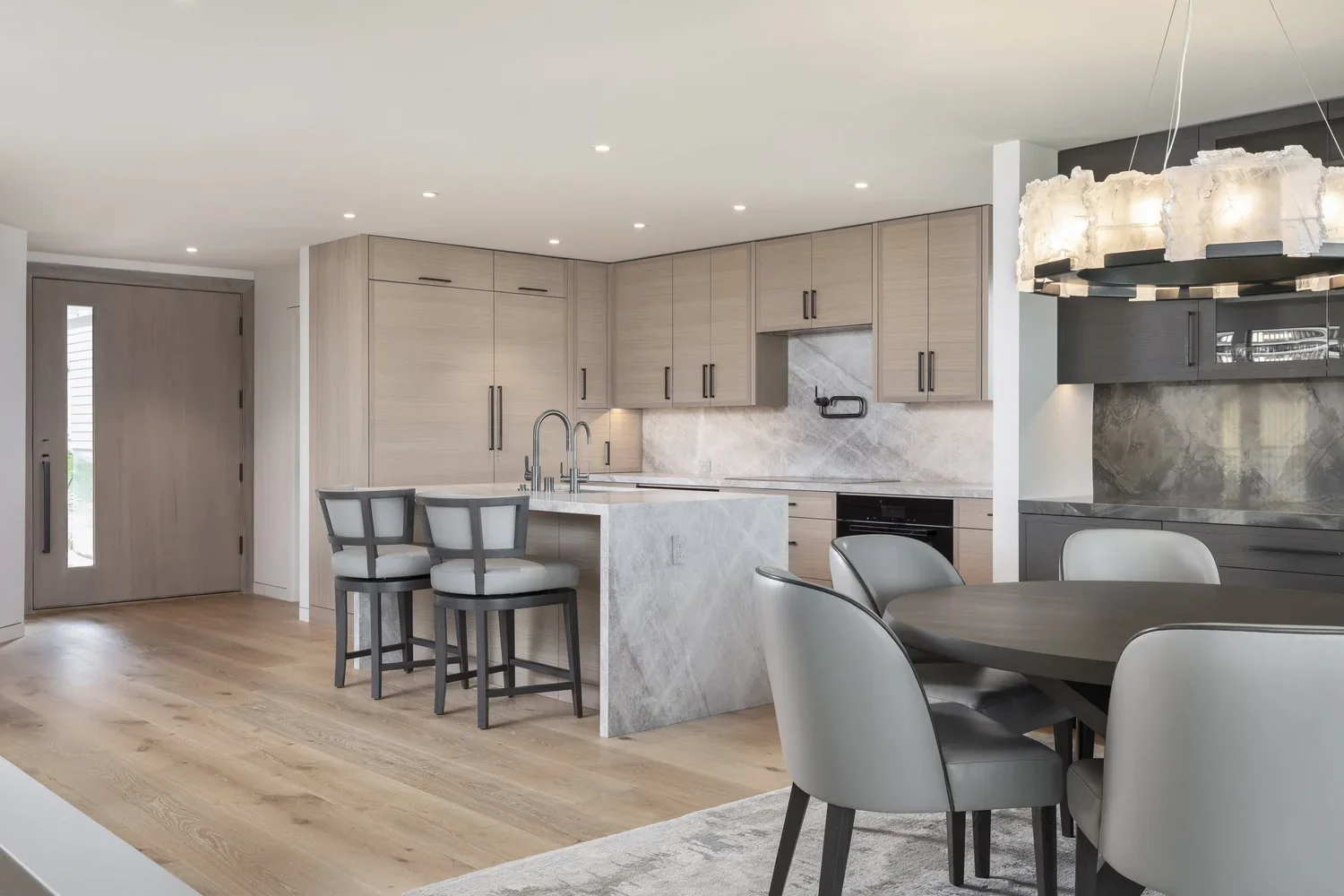 Interior_of_Sea_Mist_Home_in_Carmel_Showing_Dining_Area_and_Kitchen_With_Modern_Grey_And_Dark_Finishes.webp