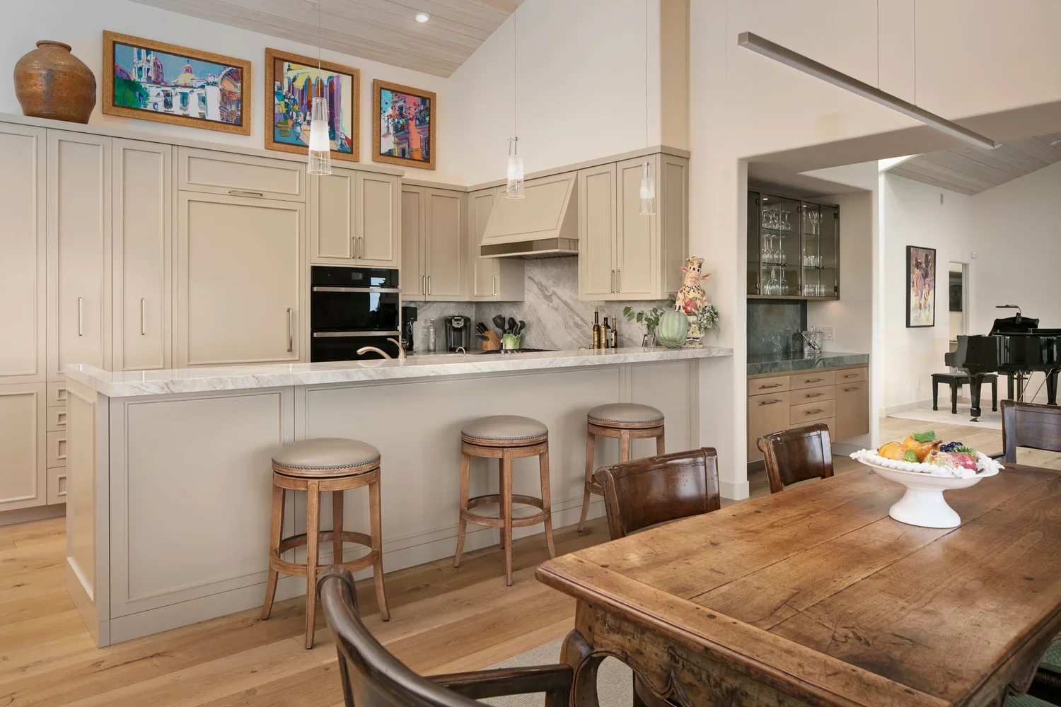 Interior_of_Carmel_on_the_Sand_House_Showing_Kitchen_With_Pull_Up_Stools_and_beautiful_Wood_Dining_Table.webp