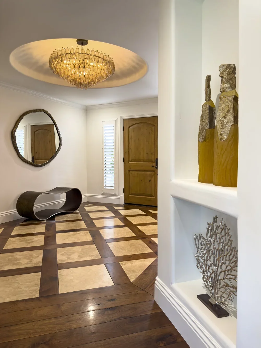 Interior_of_Quail_Modern_House_Showing_Entryway_With_Modern_Sculptures_and_Beautiful_Amber_Glass_Chandelier.webp