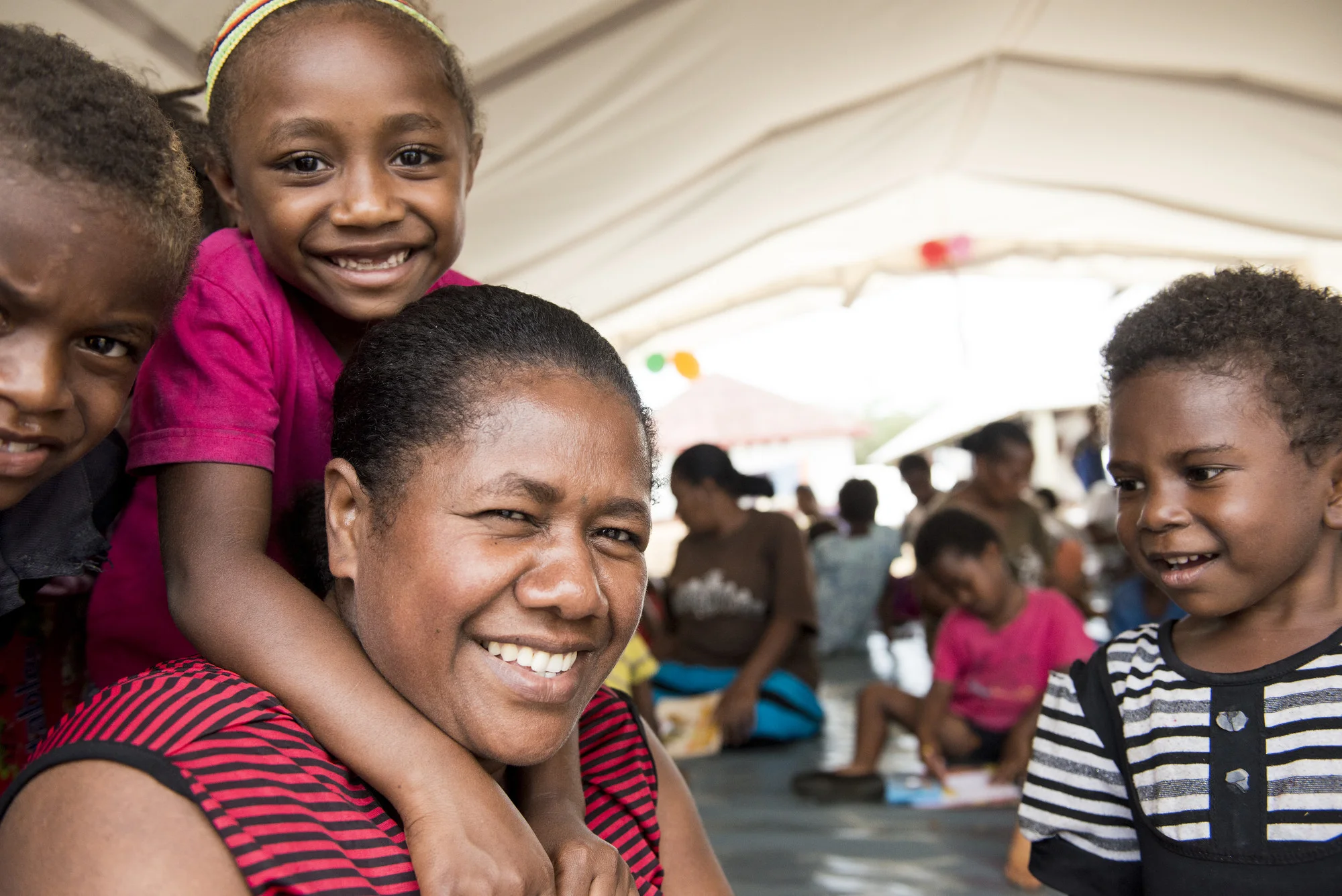 Photo caption: “This island is different, it’s a big island … the kids are very amazed to see so many people, so many trucks. The town is too busy and too noisy … If the Child Friendly Space wasn’t here, they would be with their mums, running around, doing nothing.” Rosanna is a mother of four, who was evacuated to Chapuis Stadiu. Photo credit: Save the Children.