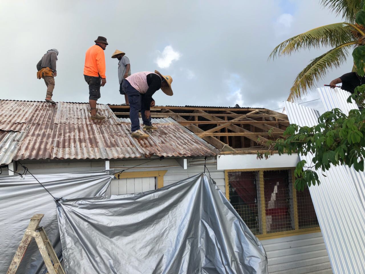 Photo caption: The field team taking off the tarpaulin and starting on the reconstruction. Photo credit: CARE Australia. Date: May 2018.