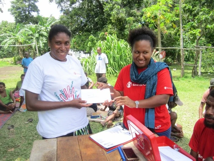 Above: An Ambae resident who evacuate to nearby Maewo island to escape intense ash that continues to be spilled from the Monaro volcano on Ambae receives cash through the Cash for Work program.