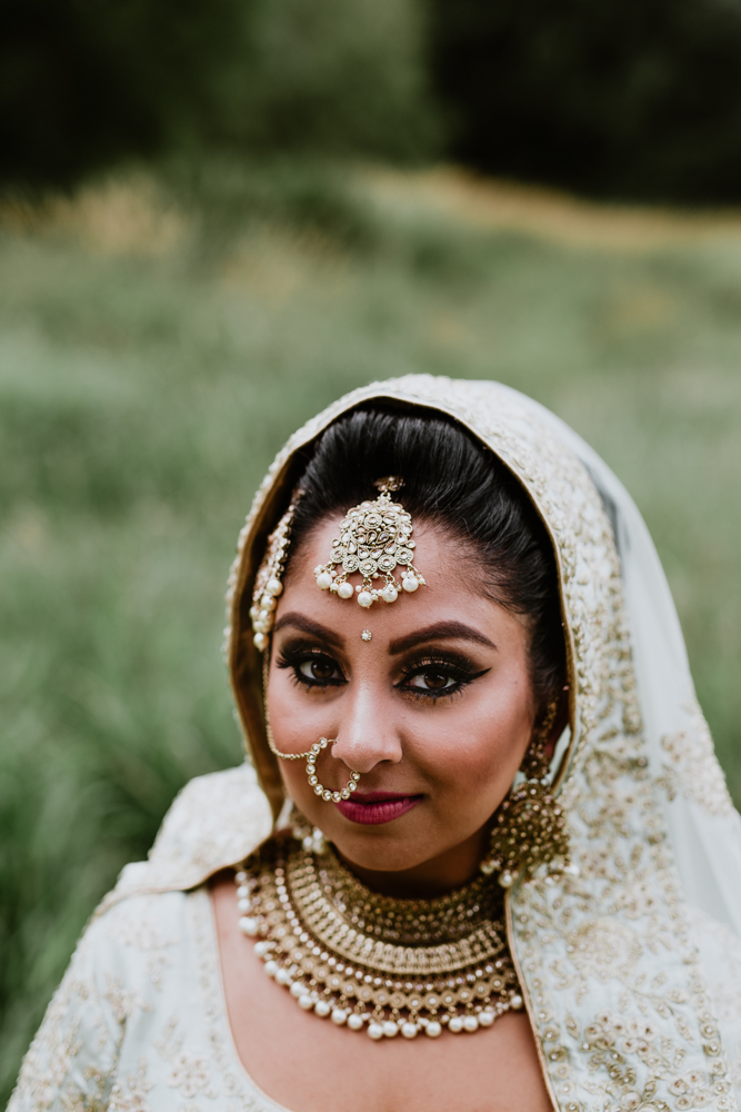 indian bride standing in the middle of a field