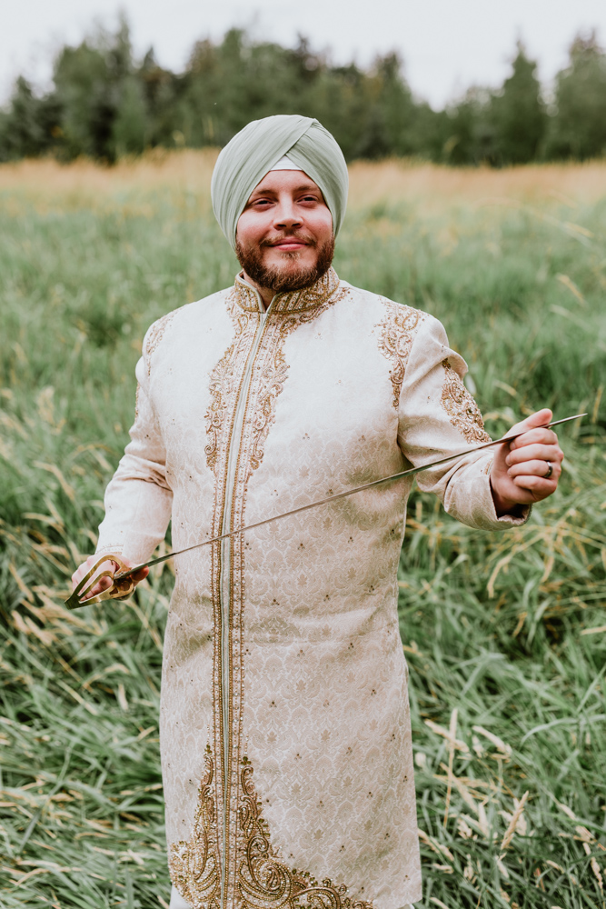 indian groom standing in field.jpg