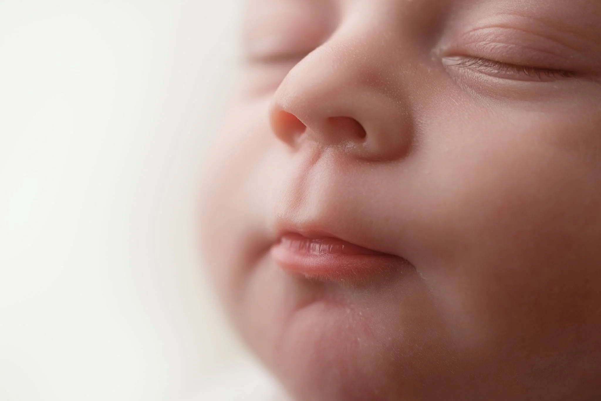 Close-up of a young child's face, showing closed eyes, nose, and lips with soft-focus background.