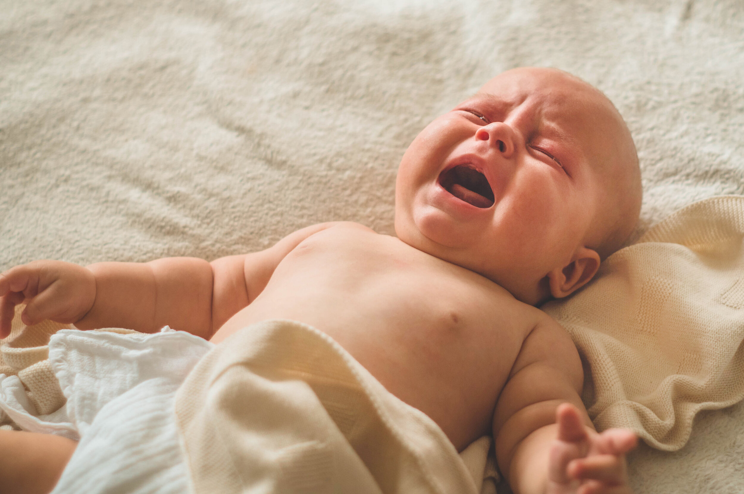 Почему новорожденный хрюкает. Малыш лежит. Плачущий грудной ребенок. Грудничок плачет. Новорожденные дети плачут.