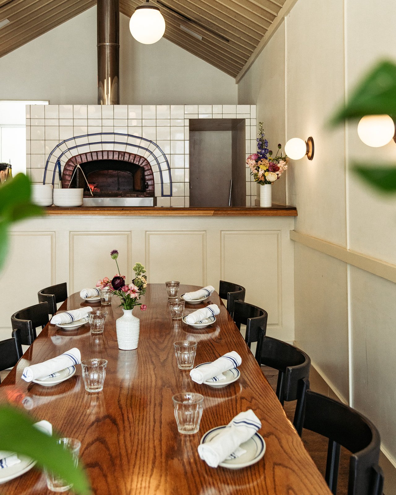 dining table with pizza oven in background