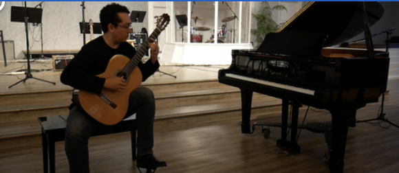 Guitar teacher performing at recital.png