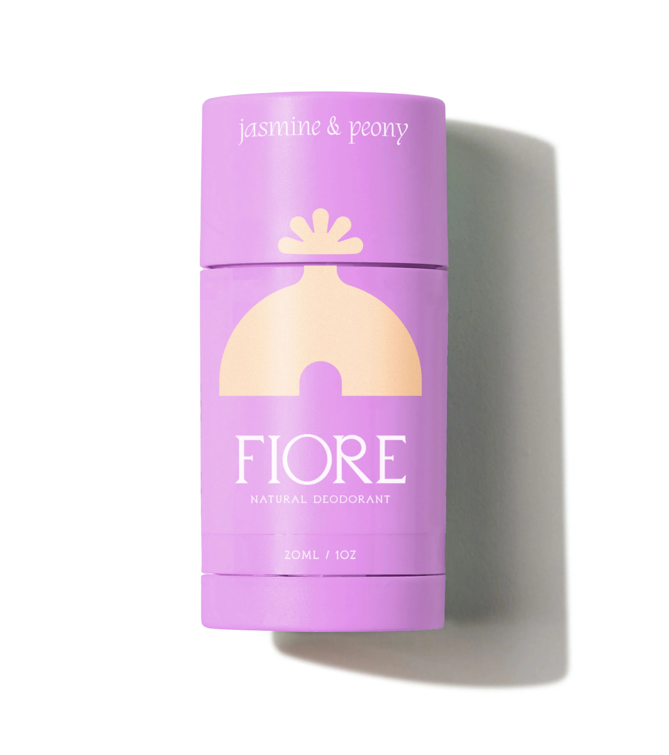A purple container of Fiore natural deodorant with jasmine and peony scent, standing on a white surface, casting a shadow.