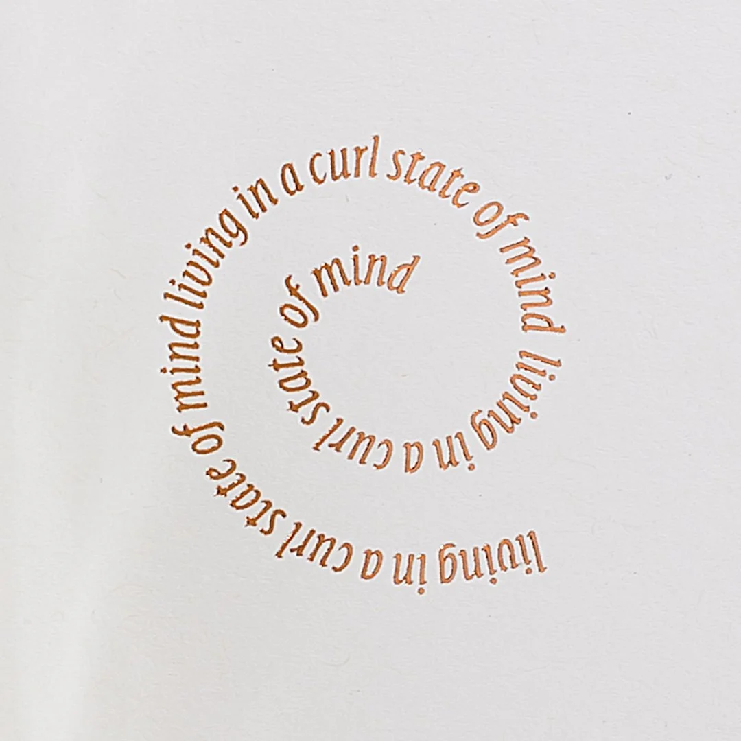 Text written in a spiral reads: "living in a curl state of mind" on a plain white background.