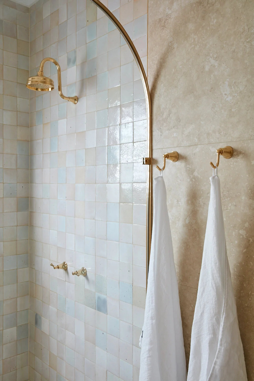  Three Birds Renovations House 13 bathroom featuring handmade square shower tiles, an arched glass shower screen, brass tapware and natural stone wall tiles. 