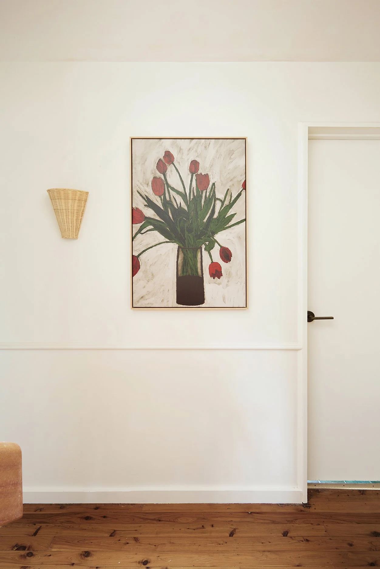 Three Birds Renovations Hallway Transformation with tulip artwork, woven wall sconce and warm neutral walls.