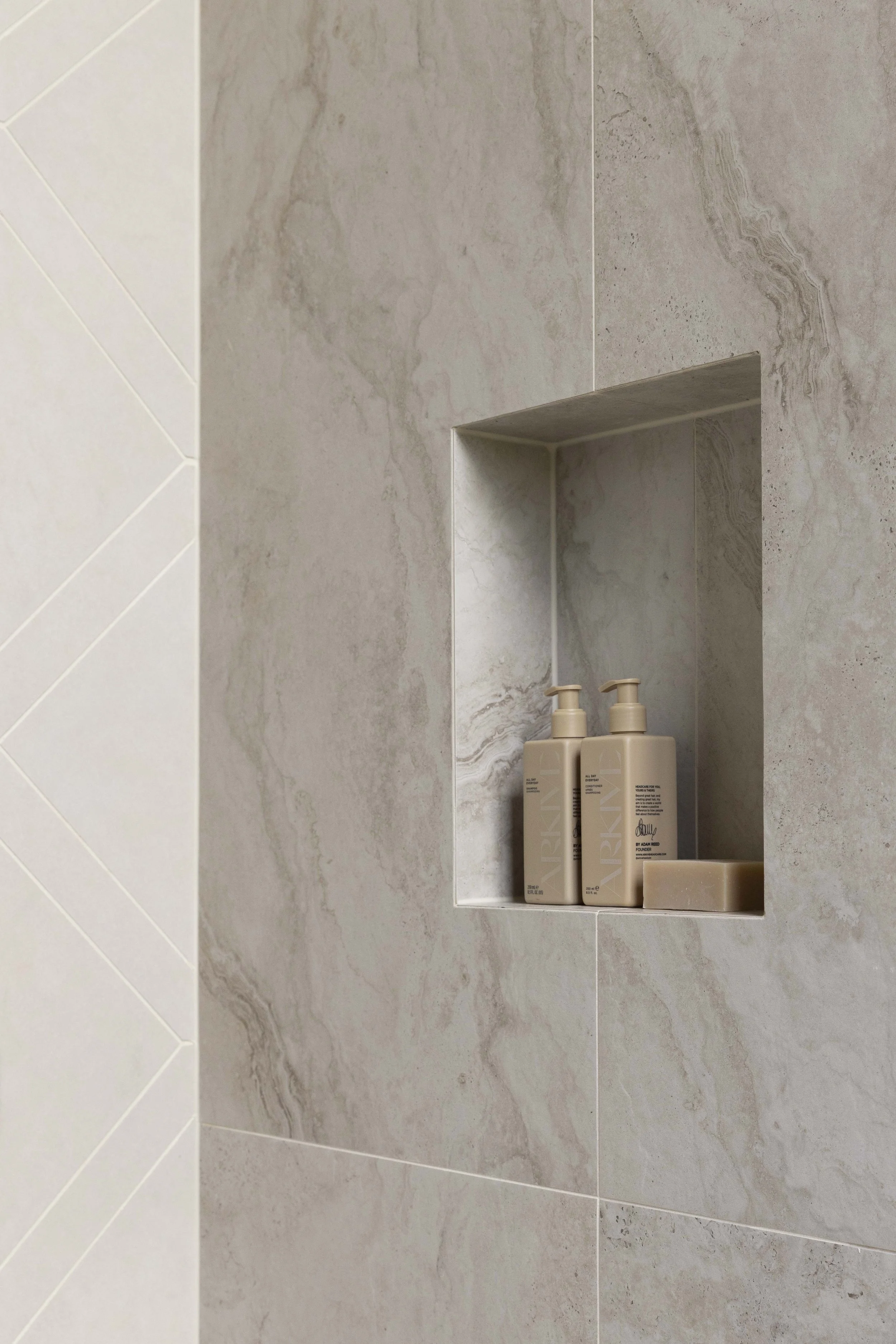  Three Birds Renovations House 16 bathroom niche detail with marble-look tiles, a recessed shelf and soft neutral tones. 