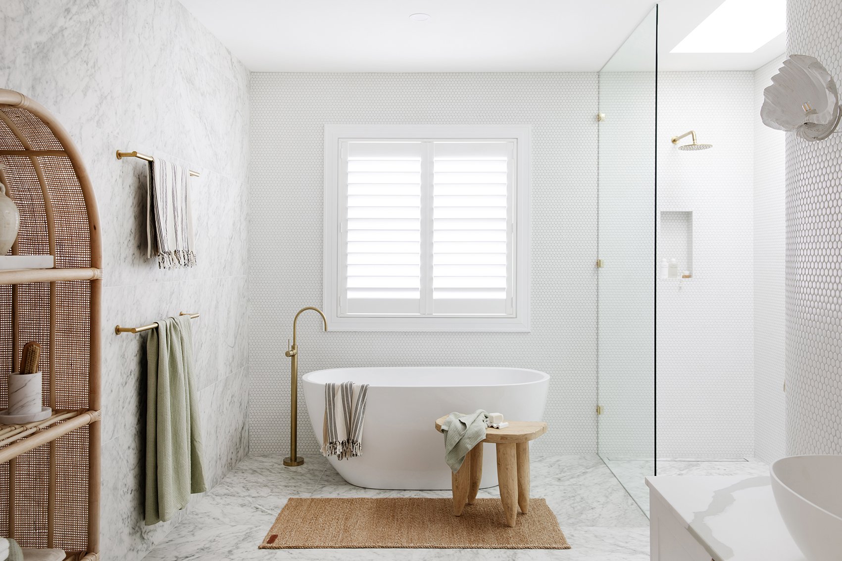 Three Birds Renovations House 14 bathroom with a freestanding bath, marble surfaces, brass tapware and a walk-in shower.