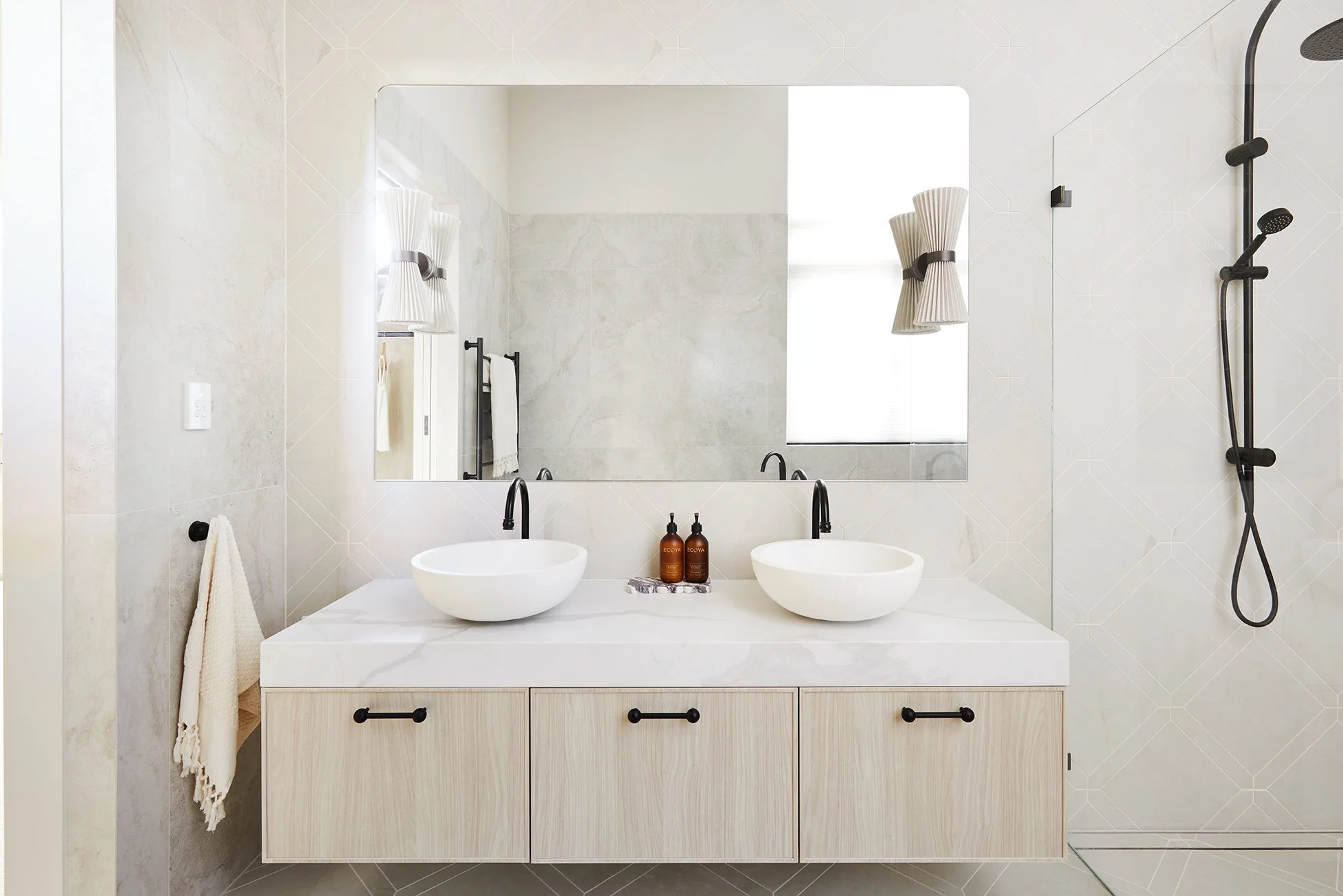 Three Birds Renovations House 16 bathroom with double vanity, vessel basins, black tapware and soft neutral tiles creating a calm, modern space.
