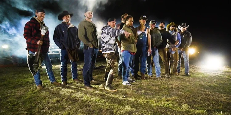 Granger Smith and cast standing in a field at night with smoke effects for the Holler video.