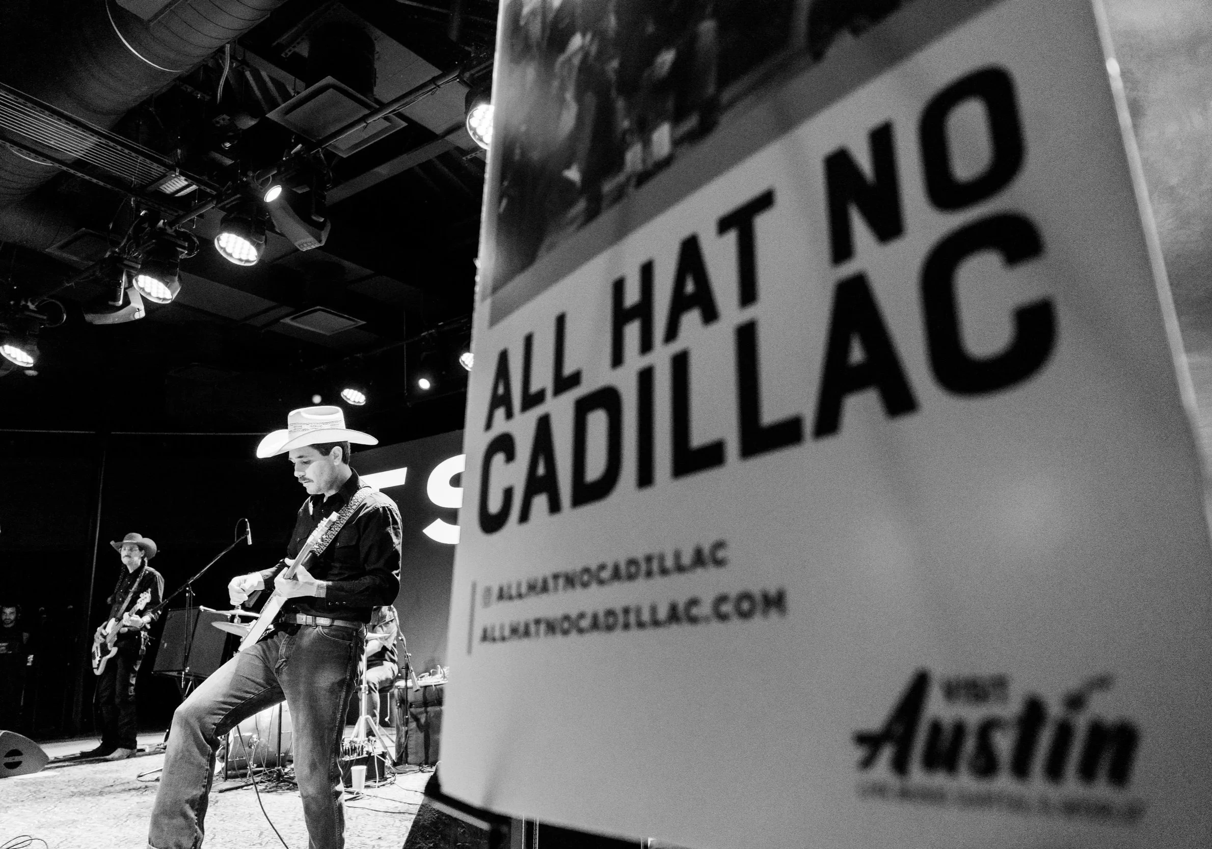 Country band performing live on stage at an Austin Texas music event in black and white photography.