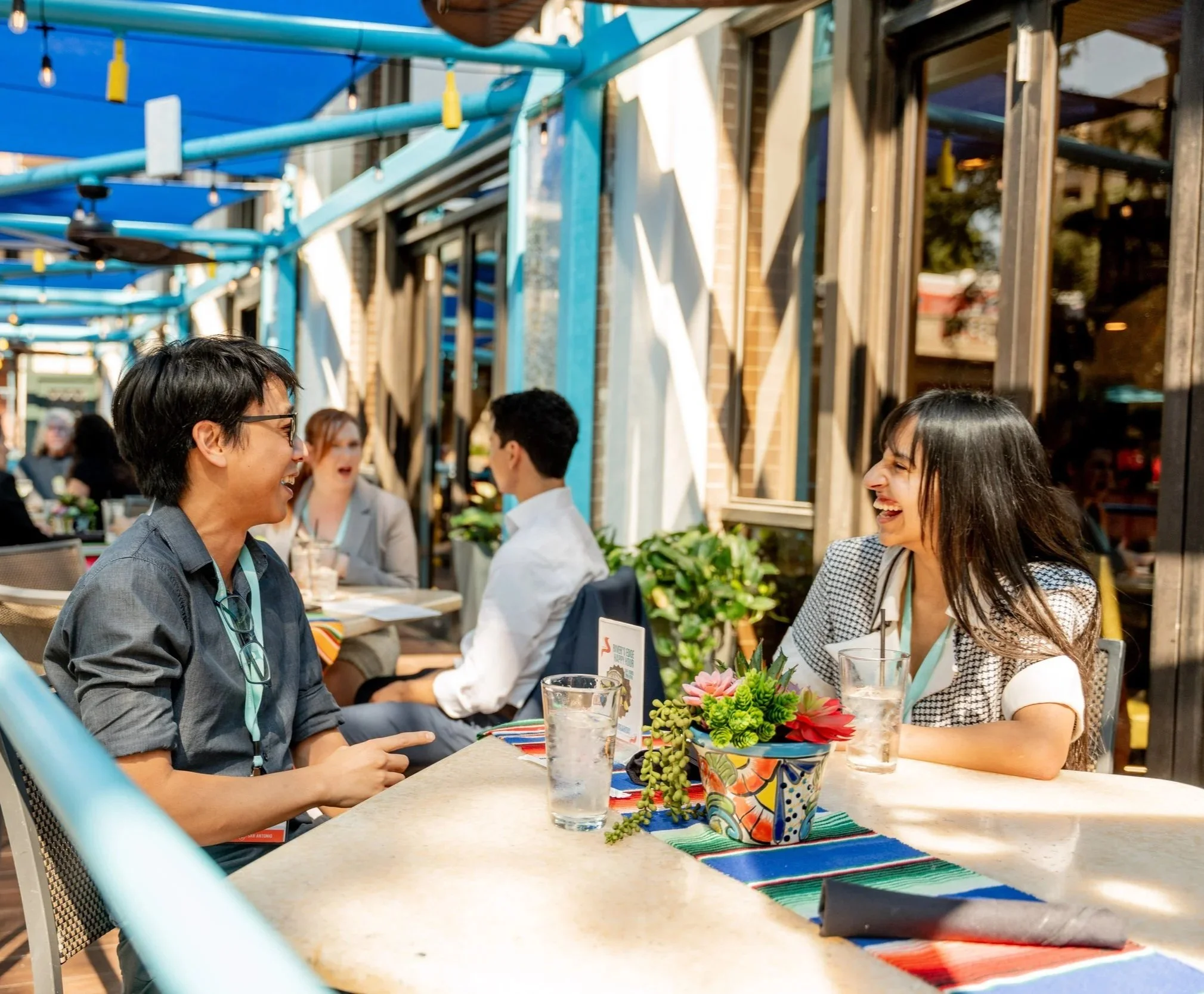 Couple laughing at an outdoor restaurant patio for commercial hospitality and dining photography in San Antonio.