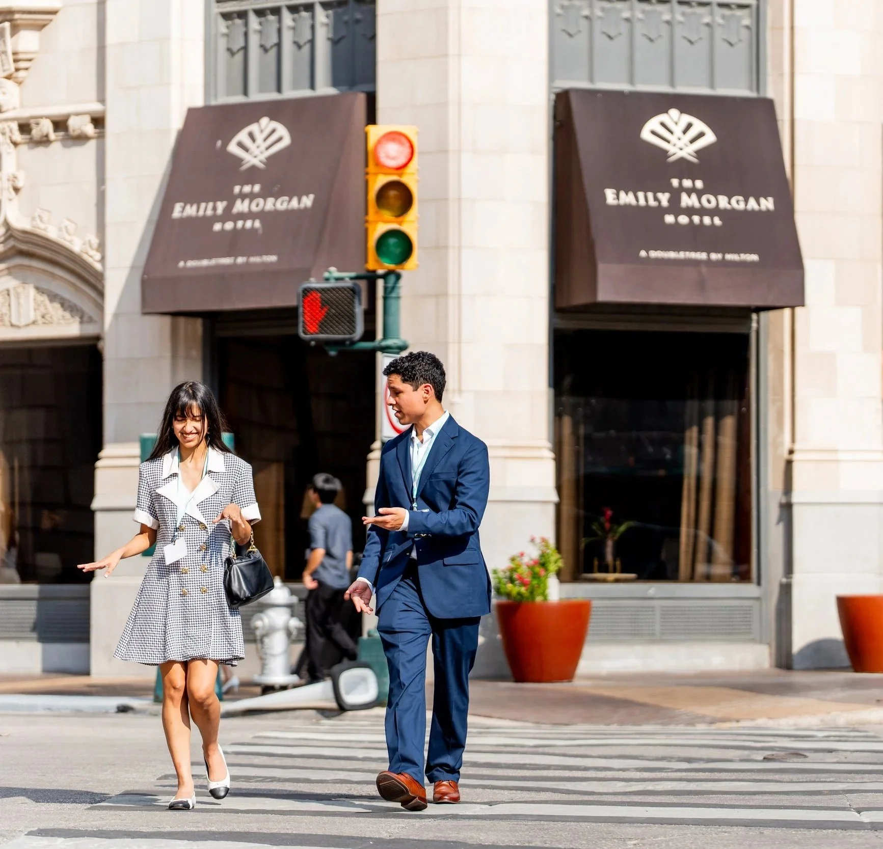 Couple walking past the Emily Morgan Hotel, a Doubletree by Hilton in downtown San Antonio after their stay.