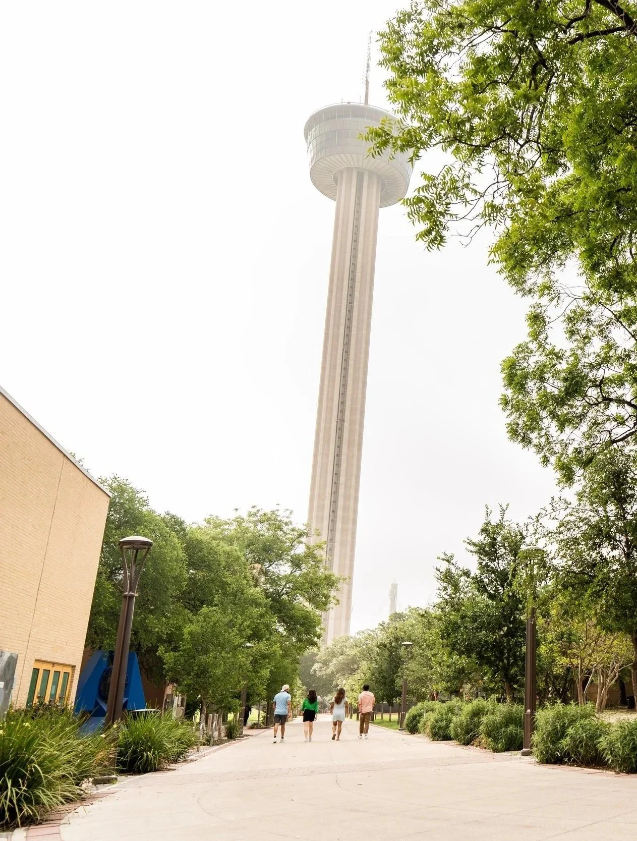 Group of visitors walking toward the Tower of the Americas in San Antonio Texas travel photography.