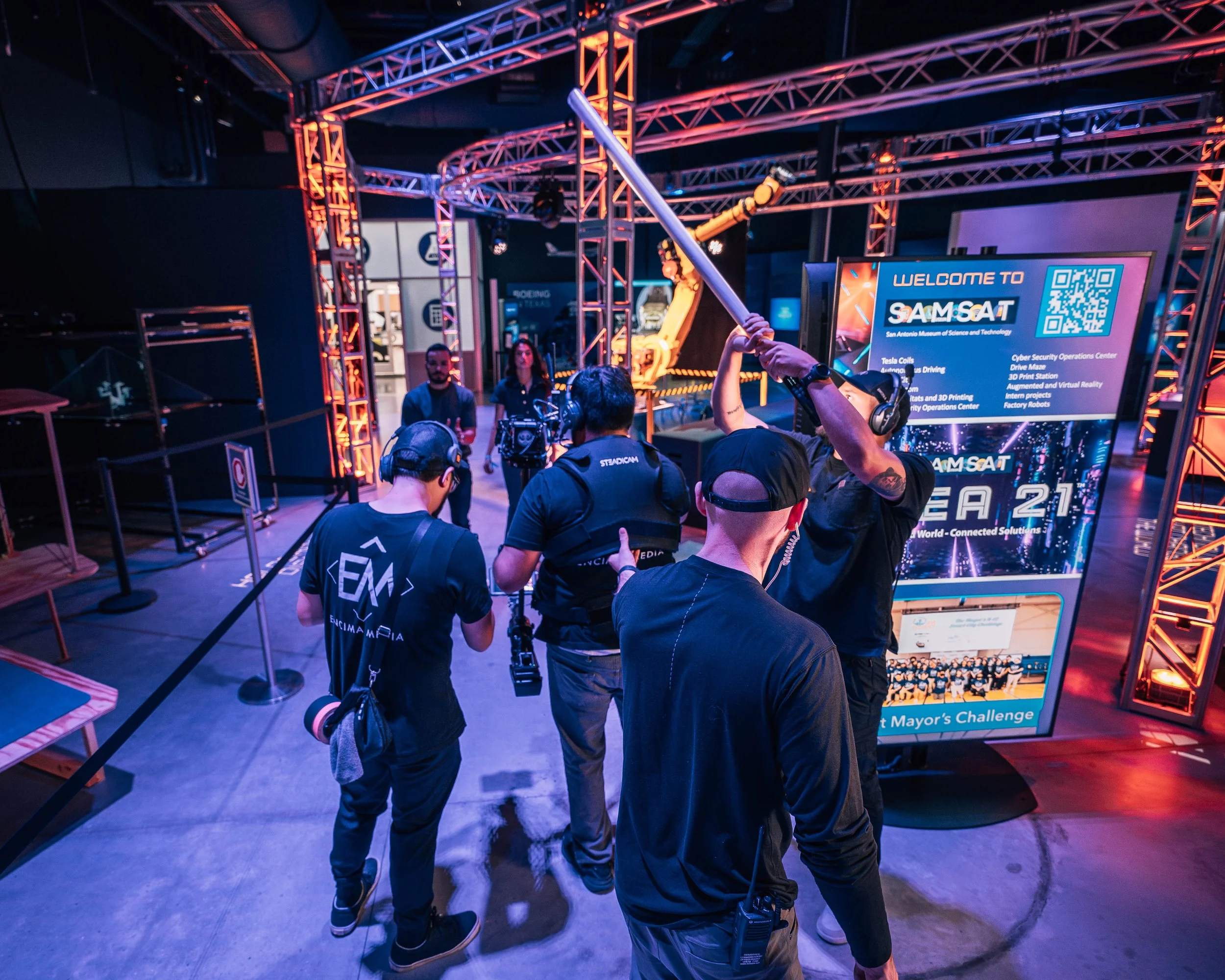 Video production crew setting up a commercial production camera rigging inside a event center.