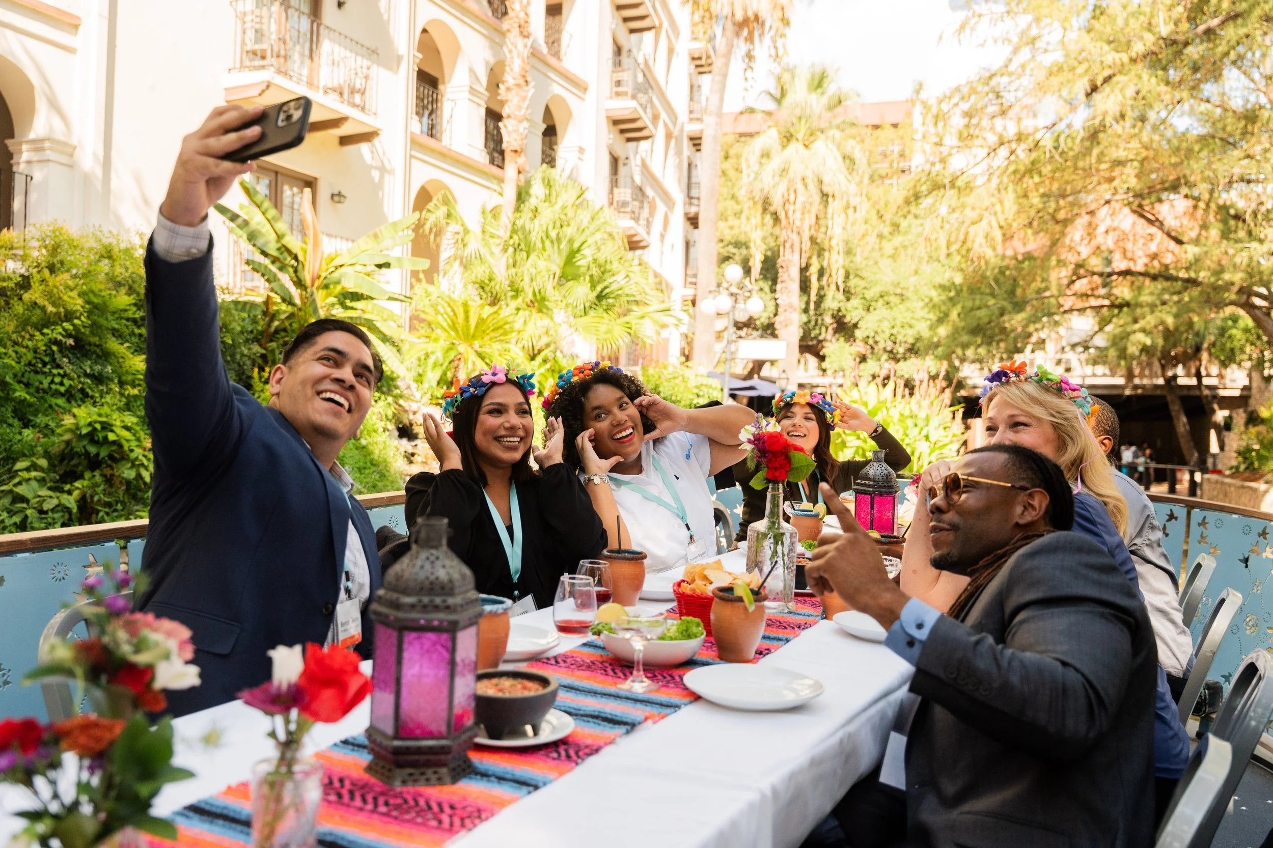 Group of smiling dining guests taking a selfie at an outdoor San Antonio dining event on the San Antonio river.