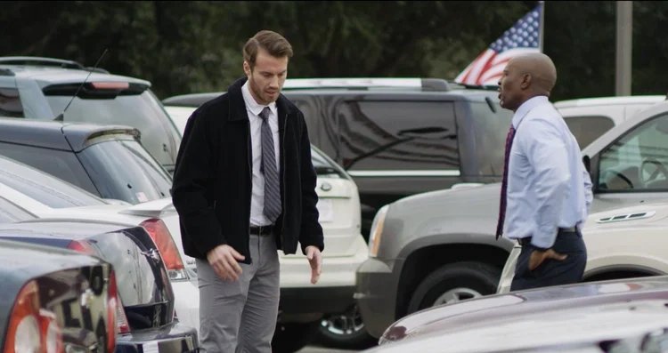Kyle Park walking though a car dealership.