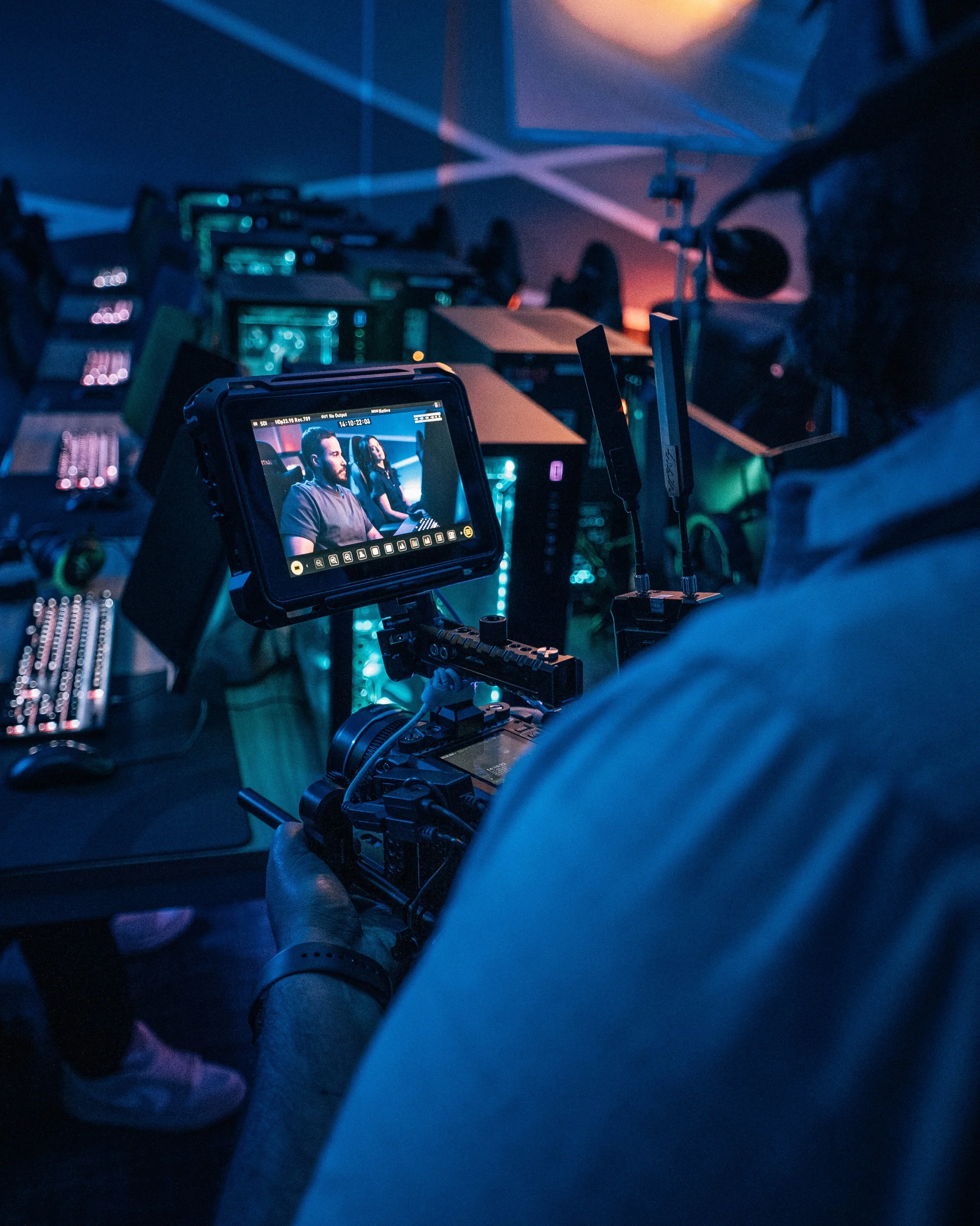 Videographer monitoring a live shoot on a camera display during a professional commercial video production.