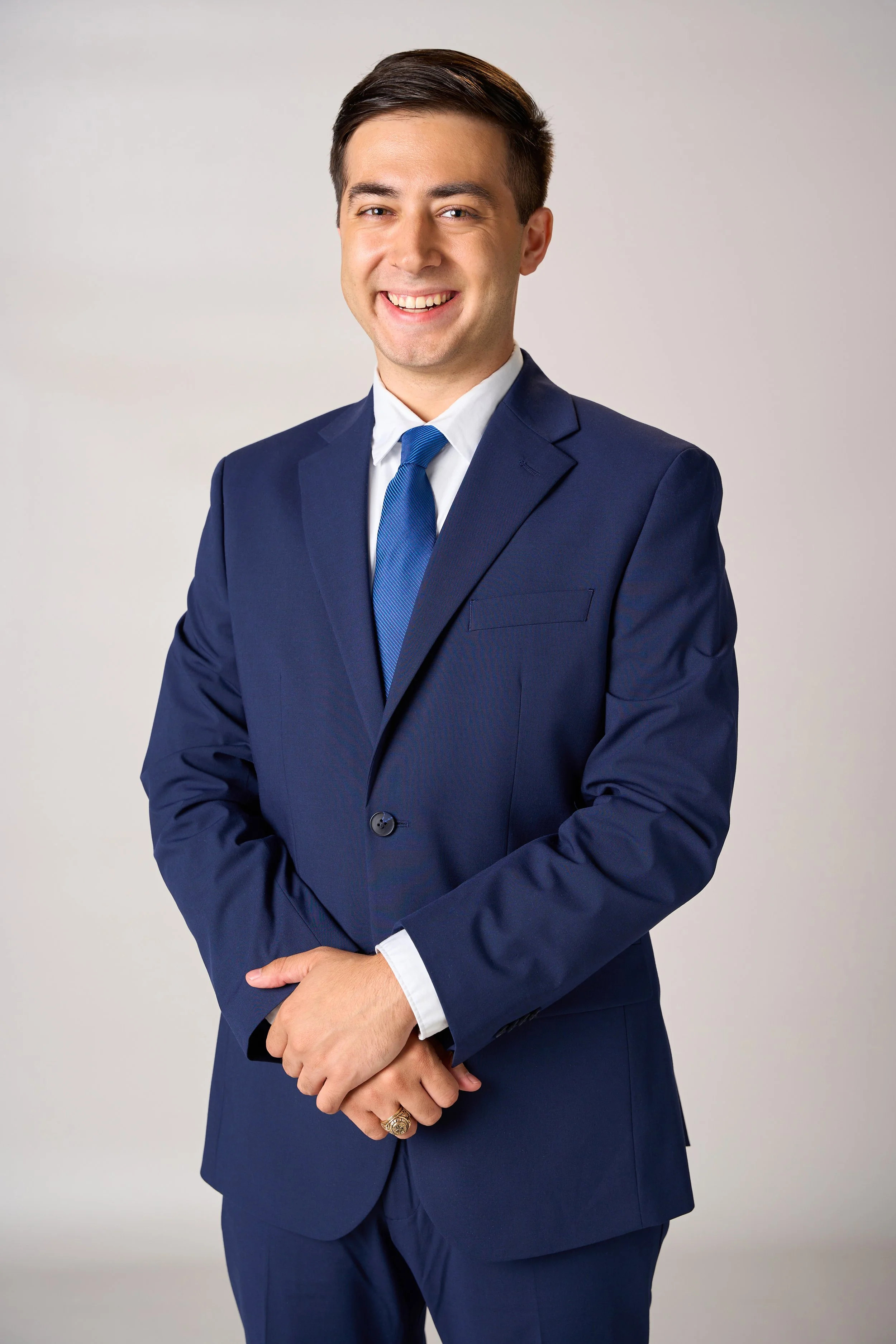 
Professional headshot of a smiling man in a navy suit for corporate and personal branding photography.