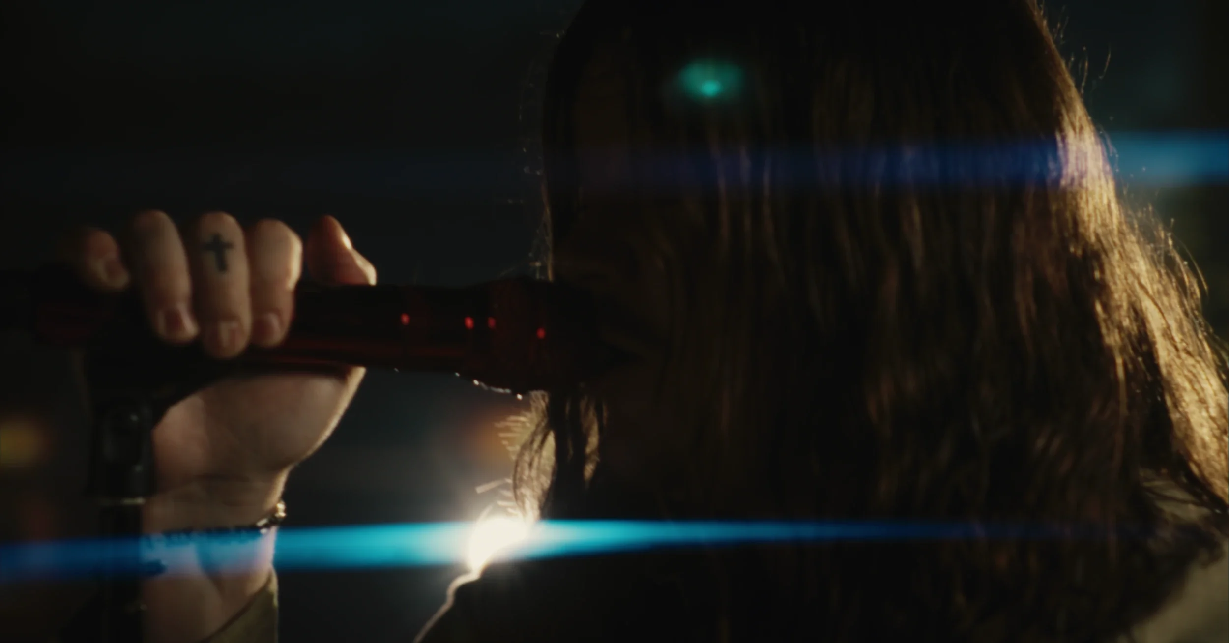 Kolby Cooper performing the song "Mama" close up to a microphone in a dark production set.