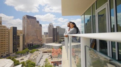 Couple on a hotel balcony overlooking the city.