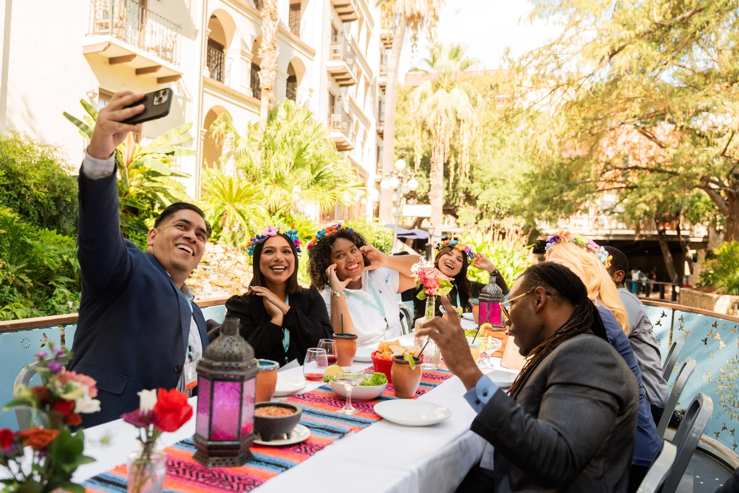 Group of smiling dining guests taking a selfie at an outdoor San Antonio dining event