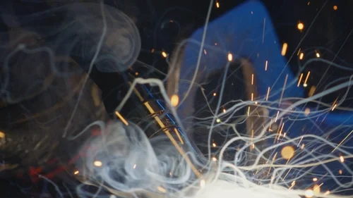 Smoke rising from the welding of the Encima Media brand logo for the 2025 reel.