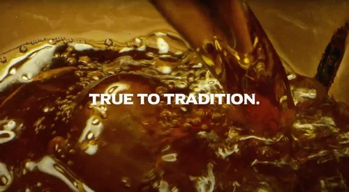 Oak & Eden bourbon whiskey flowing with the words “TRUE TO TRADITION” across the center.