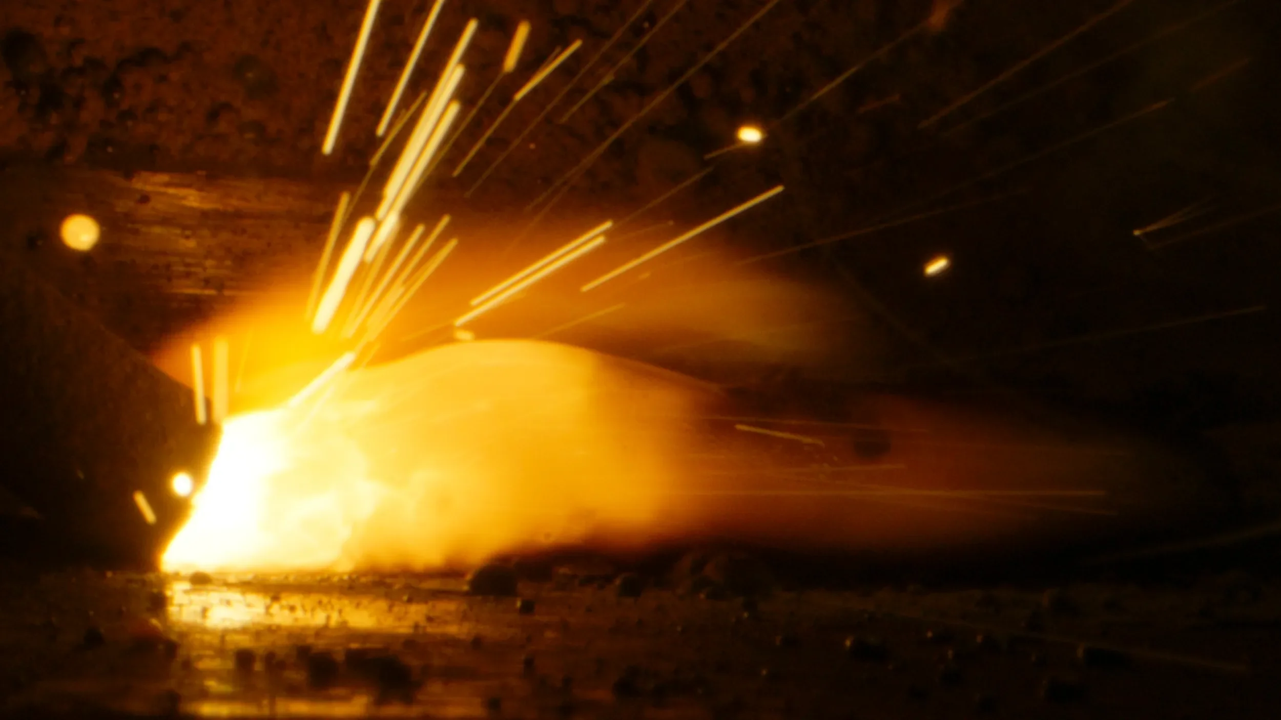 Intense heat and melted metal from the Encima Media logo being welded.