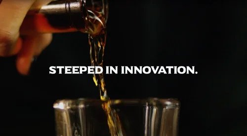 Oak & Eden bourbon being poured into a glass with "Steeped In Innovation" across the center.