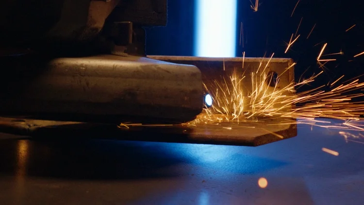 Two metal pieces being welded together as sparks fly.