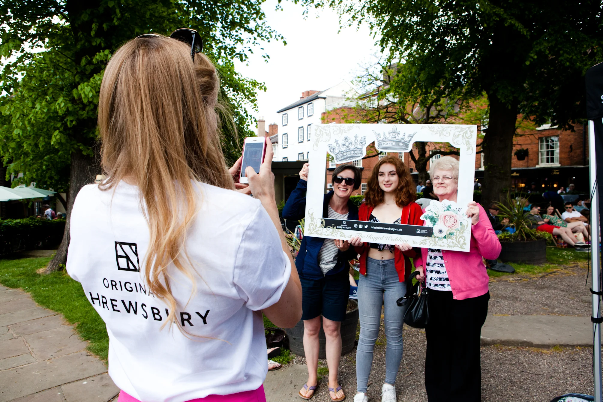  Alice Northrop taking a photo of three women in a selfie frame at the Royal Wedding screening. 