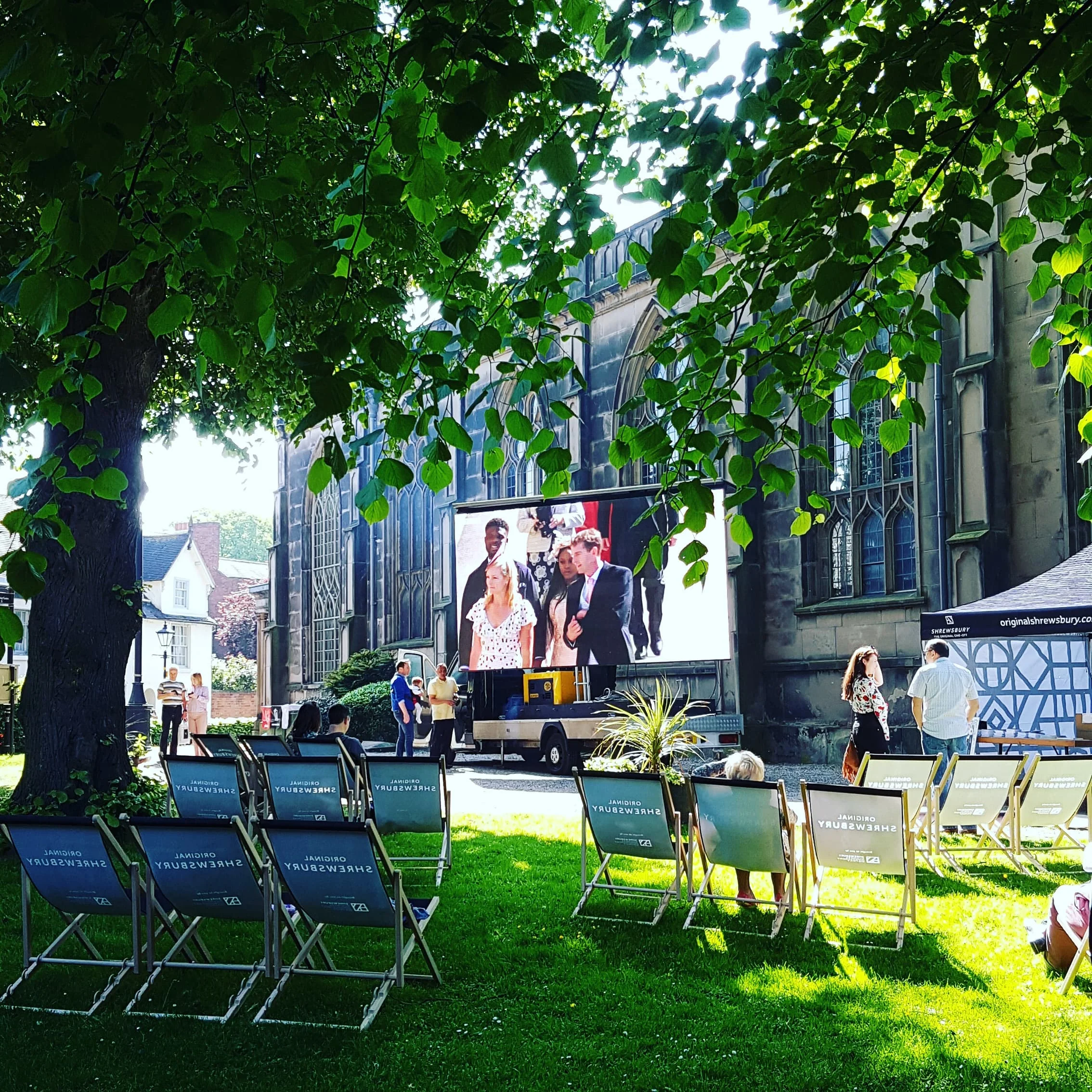  View of St Alkmund’s church grounds with big screen and branded deckchairs. 