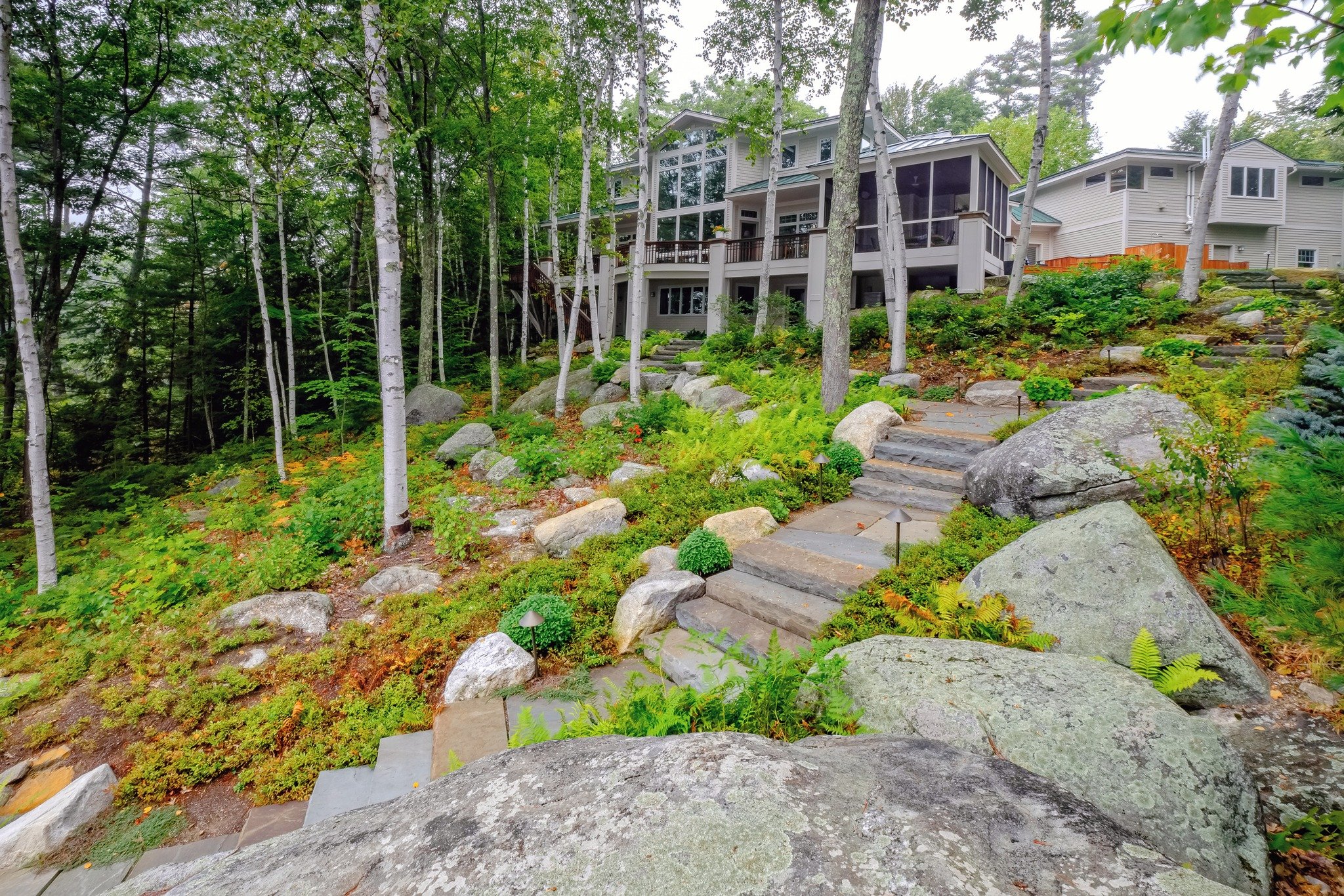 Perfectly blending with the property&rsquo;s natural beauty, these full-color natural-cleft bluestone steps and landings enhance the strength and longevity of this lakeside landscape.  Classic NH native ingredients incorporated and featured within th
