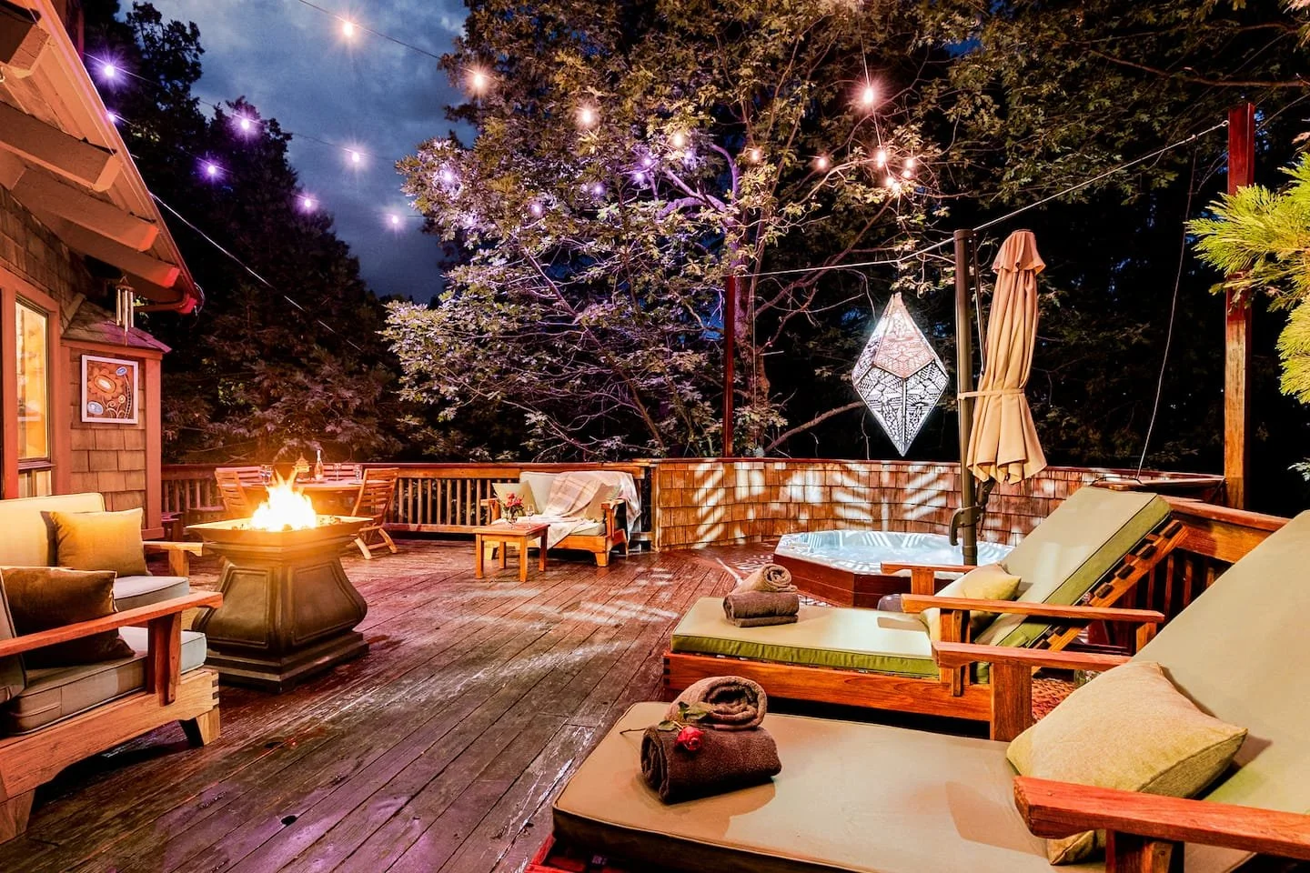 Hot tub and firepit glowing at night on the deck of Faerie House Idyllwild