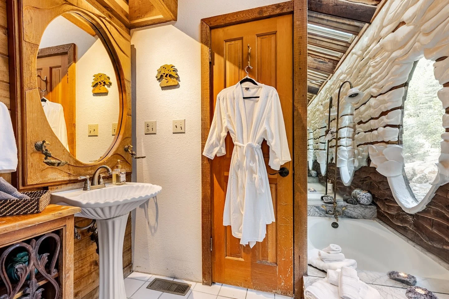 Soaking tub beside a textured art wall with forest windows at Faerie House Idyllwild