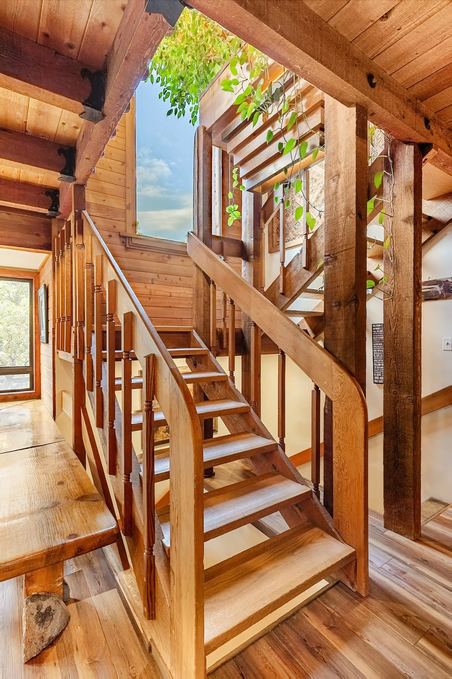 Dining nook beneath the staircase with tall forest-view windows at Faerie House Idyllwild