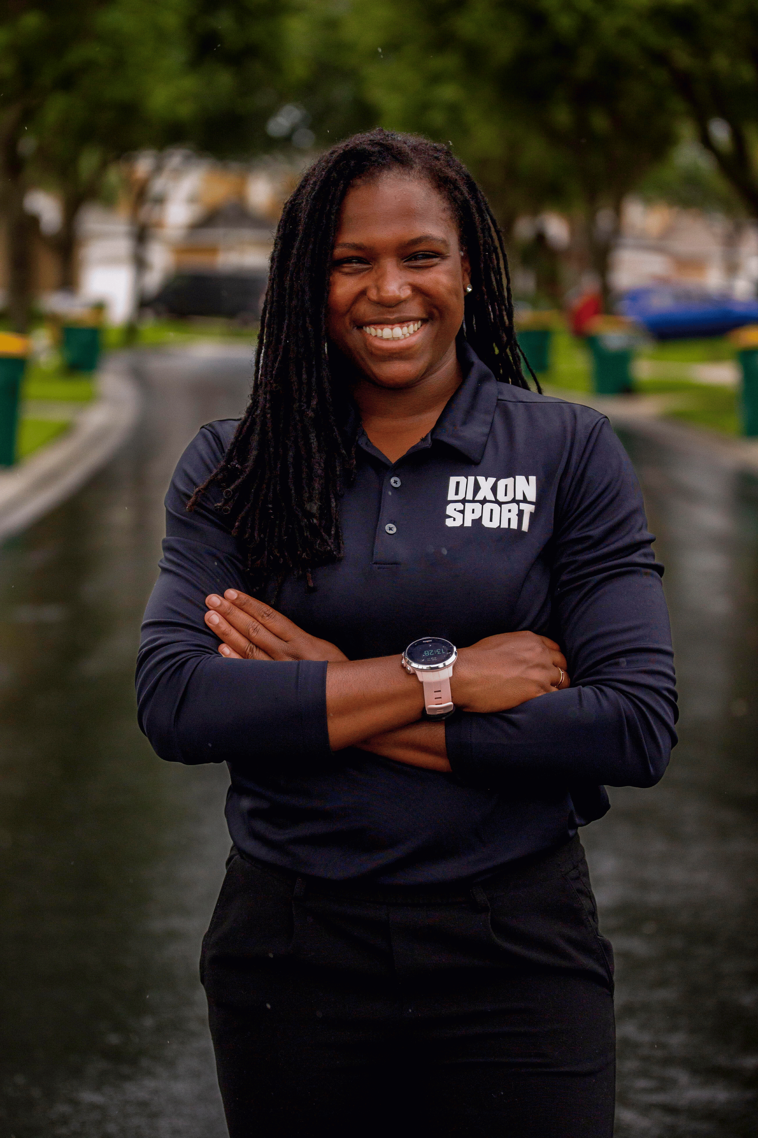 portrait of Sheila smiling woman with long locs, standing outdoors